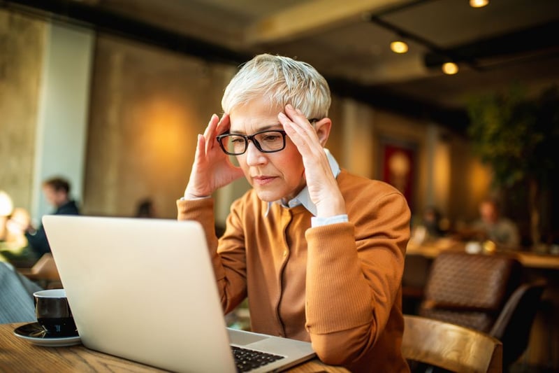 Unternehmerin am Laptop, sichtlich unter Druck